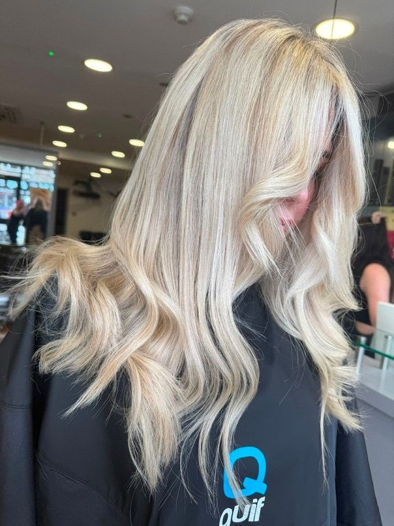 Bright blonde colour on long, loosely waved hair, coloured at Thatchairs Hair & Body
