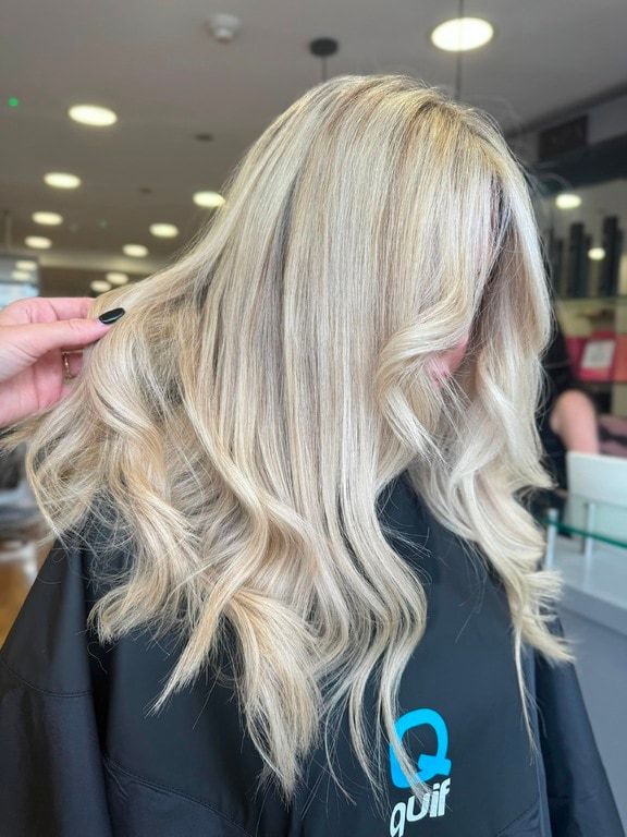 Soft blonde lived-in colour on long wavy hair, coloured at Thatchairs Hair & Body
