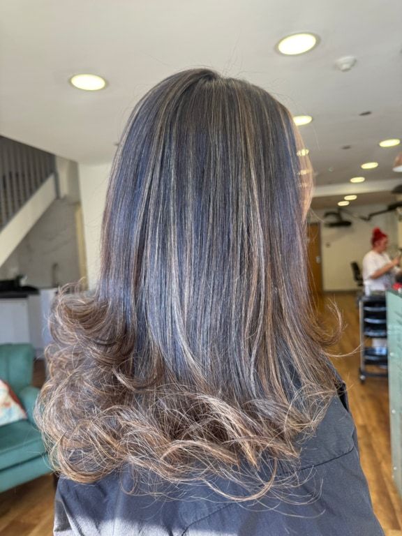 Dark brunette with lived-in highlights and curled ends, coloured at Thatchairs Hair & Body