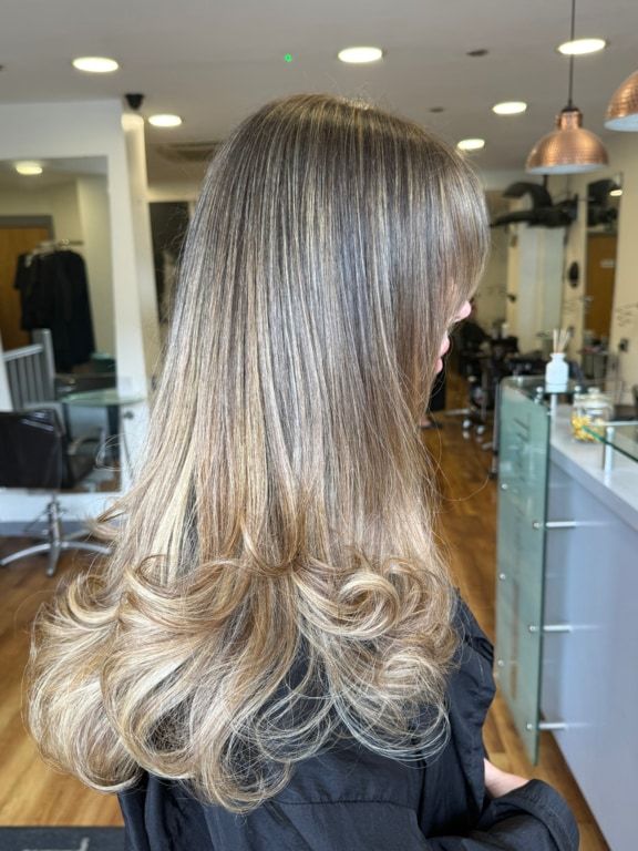 Caramel lived-in colour on long hair with softly curled ends, coloured at Thatchairs Hair & Body