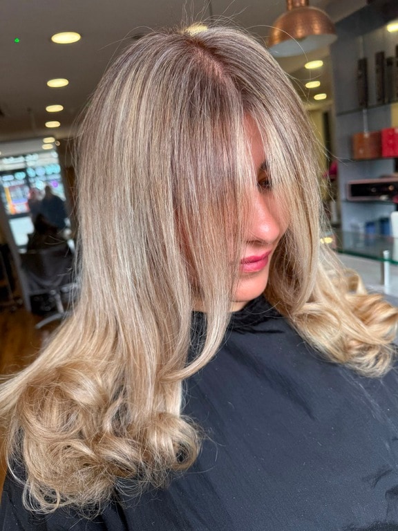 Golden blonde lived-in colour on long, softly waved hair, coloured at Thatchairs Hair & Body